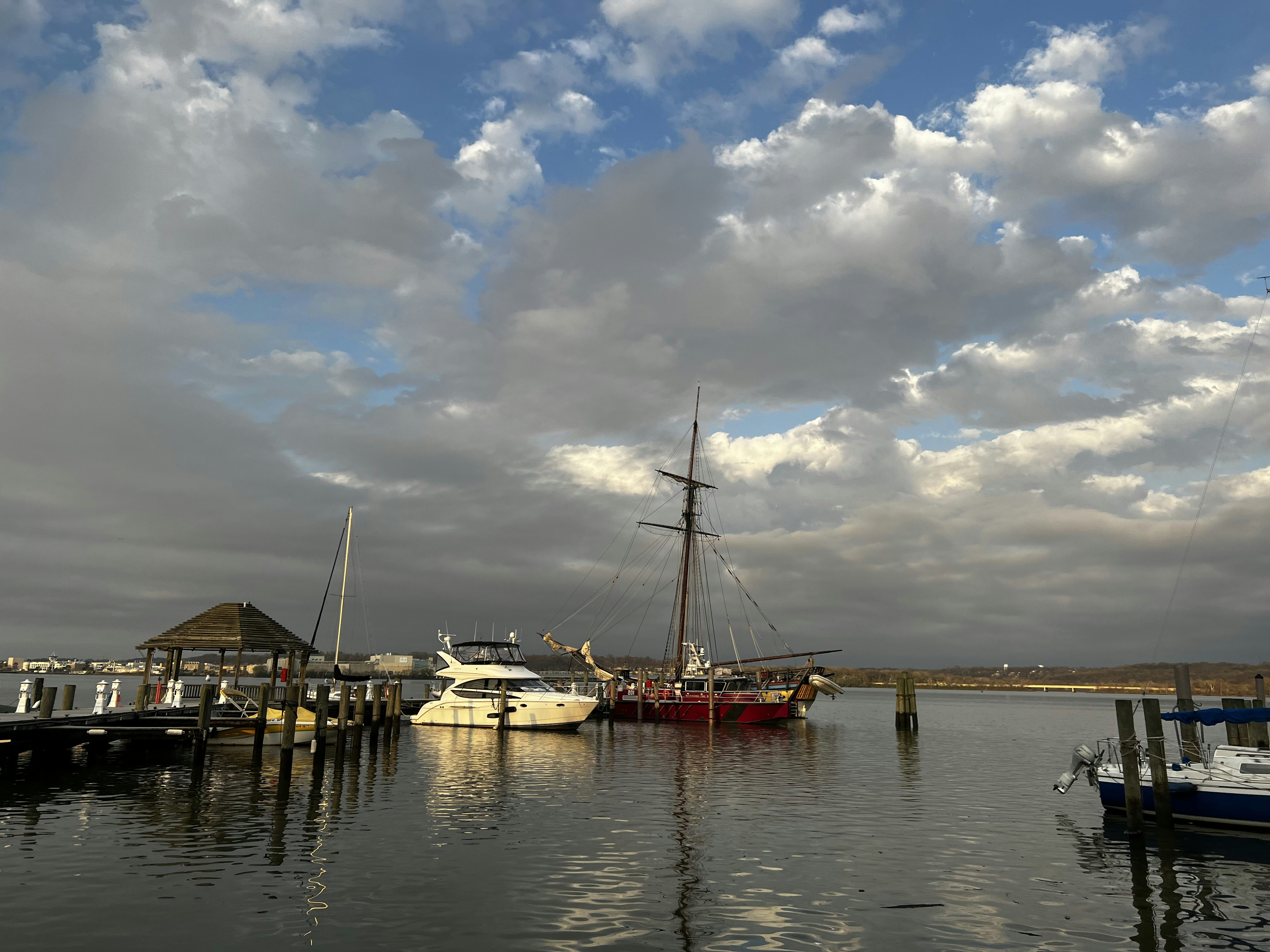 a group of boats sitting in a harbor under a cloudy sky