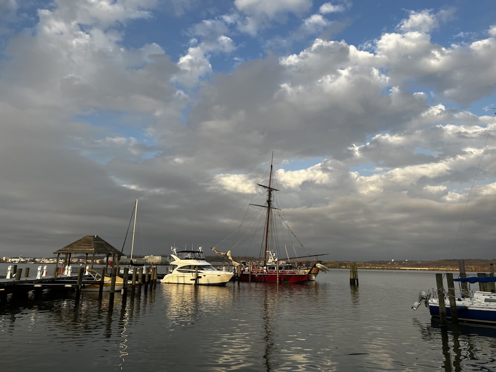 a group of boats sitting in a harbor under a cloudy sky