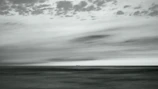 Historic photo of the ship sailing through rough seas with dramatic clouds overhead