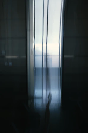 Blurred architectural video background showing natural light filtering through modern structural elements.