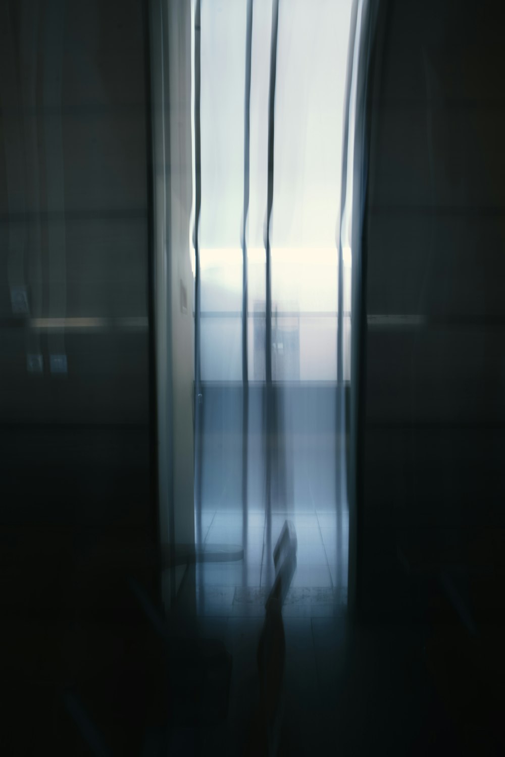 a blurry photo of a person walking through an open door