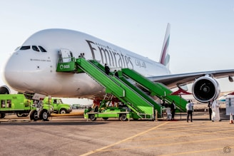 A team of ground crew members in uniform assisting passengers near an aircraft.