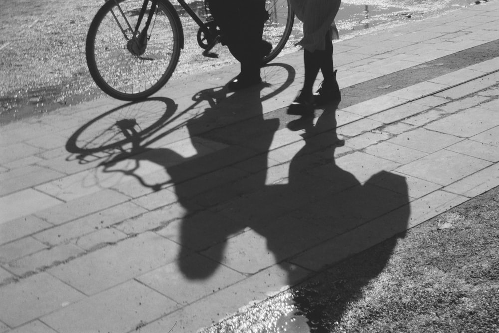 a person standing next to a bike on a sidewalk