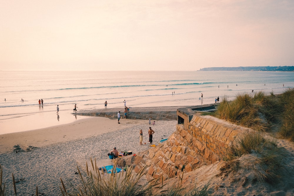 a group of people standing on top of a sandy beach