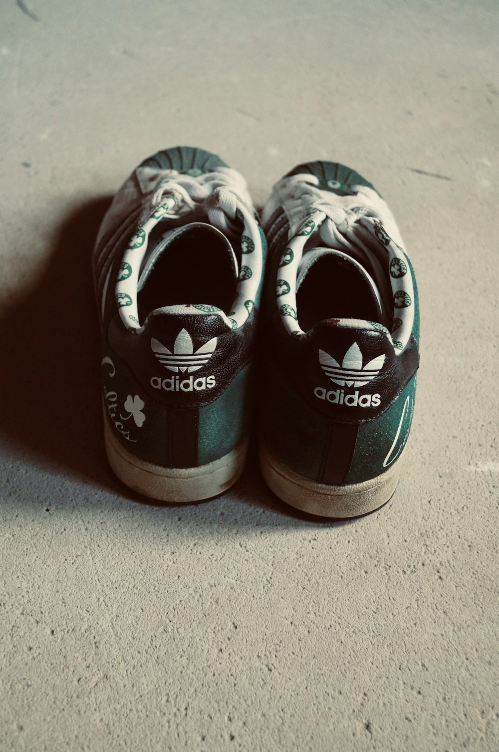 a pair of shoes sitting on top of a cement floor