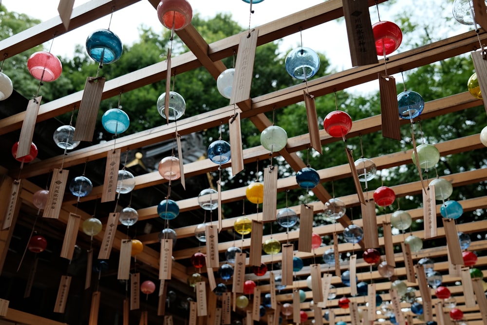 a bunch of glass balls hanging from a wooden structure