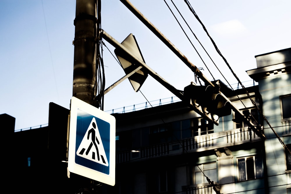 a blue and white sign hanging from the side of a pole