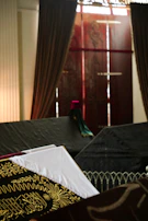 A dramatic shot of a thobe’s flowing silhouette against a backdrop of dark Moroccan tiles and golden ornamental arches.