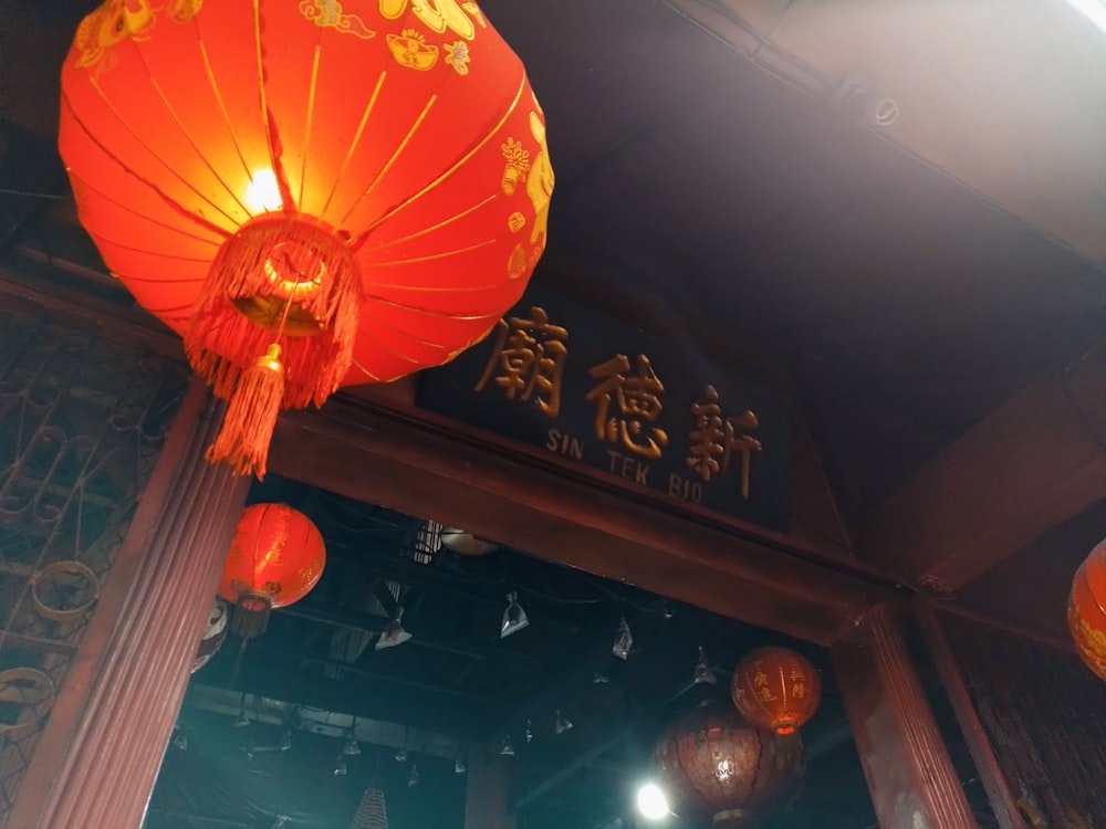 a couple of red lanterns hanging from the side of a building