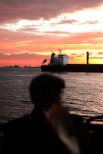 An inspiring sunset view of a large cargo ship sailing on the open sea, symbolizing career journeys.
