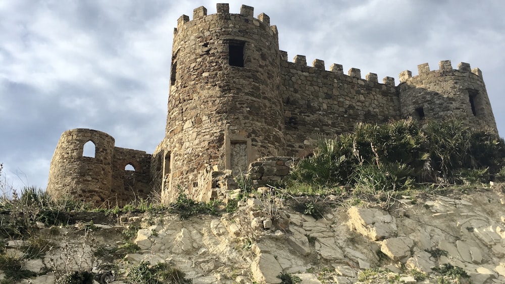 a stone castle sitting on top of a rocky hill