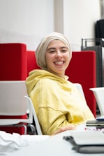 A friendly tutor and student smiling together in a cozy study space decorated with blue and yellow accents.