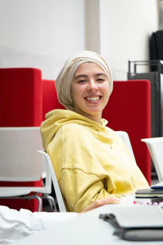 Happy person wearing colorful merch from the brand, smiling in a bright, cozy room.