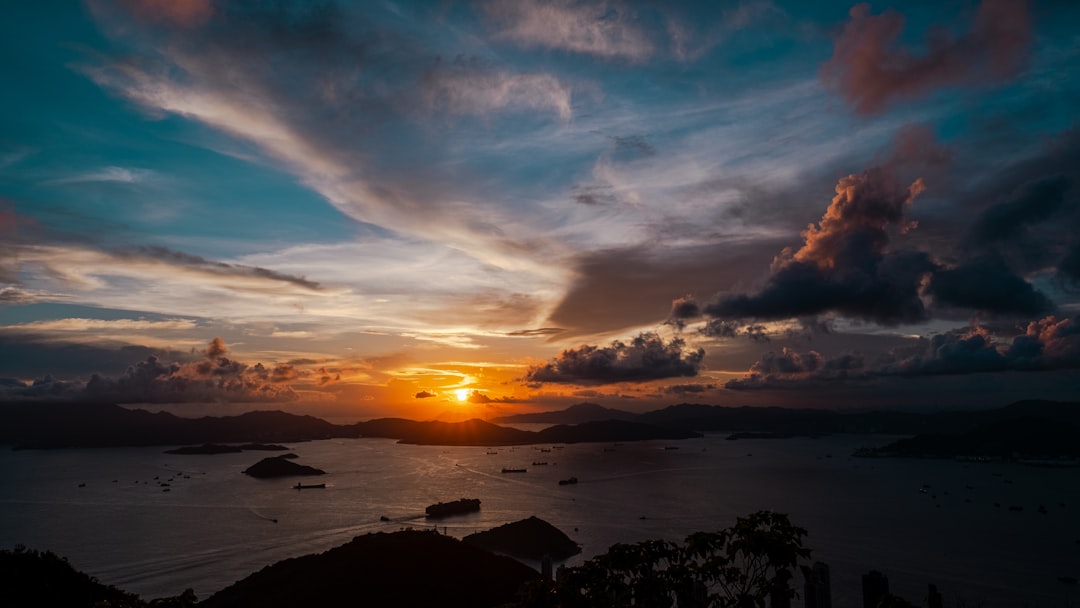 a sunset over a body of water with boats in the water,