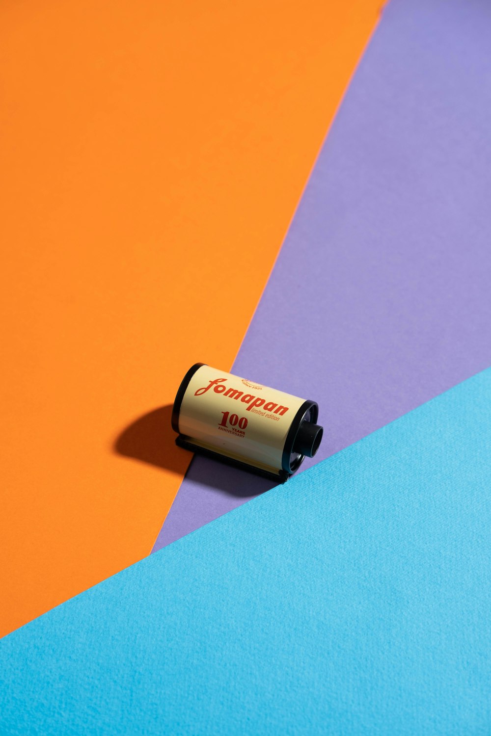 a tube of lipstick sitting on top of a multicolored surface
