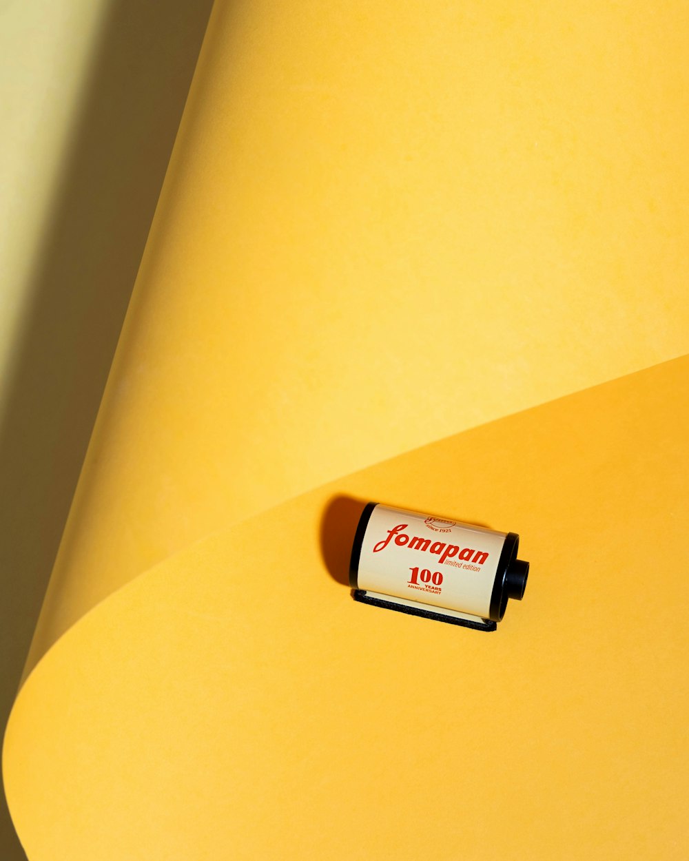 a roll of yellow paper with a small battery on top of it