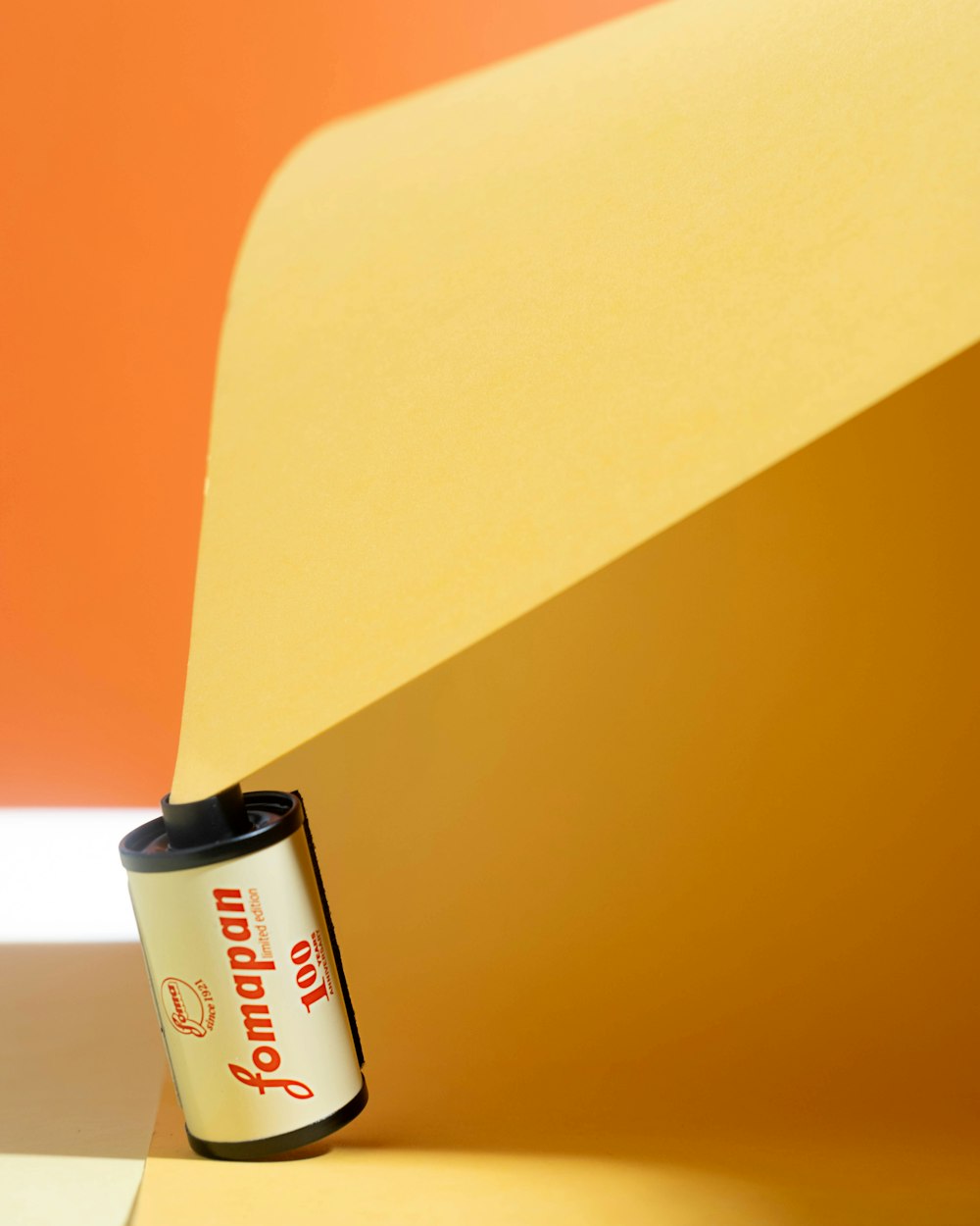 a can of soda sitting on top of a yellow piece of paper
