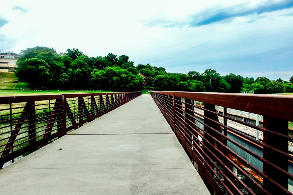 a wooden bridge with metal railings over a river