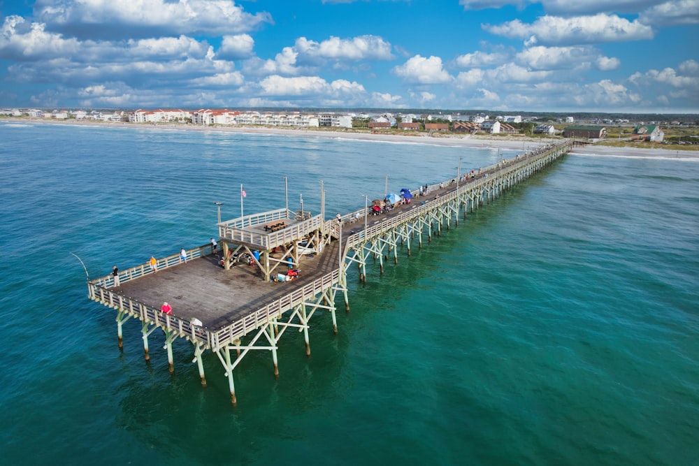 a pier with people standing on it in the ocean