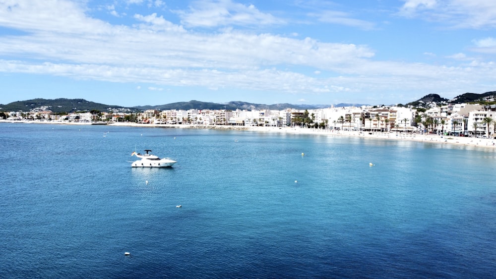 a white boat floating on top of a body of water