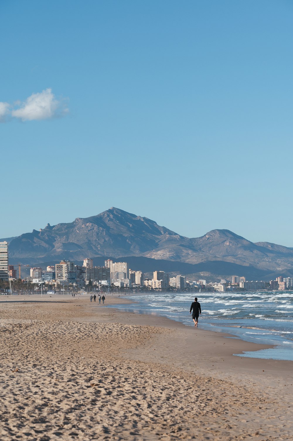 Una persona caminando en una playa cerca del océano