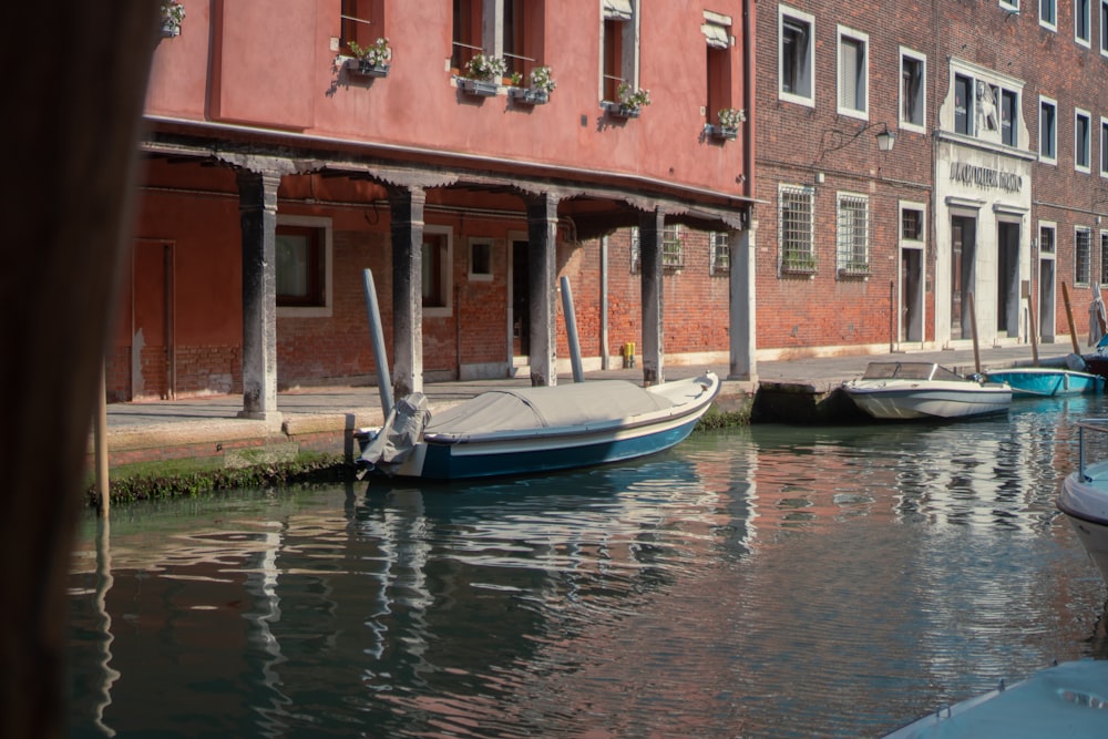 a row of boats sitting next to a red brick building