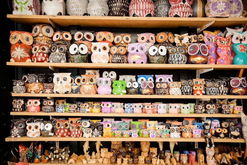 a shelf filled with lots of colorful owl figurines