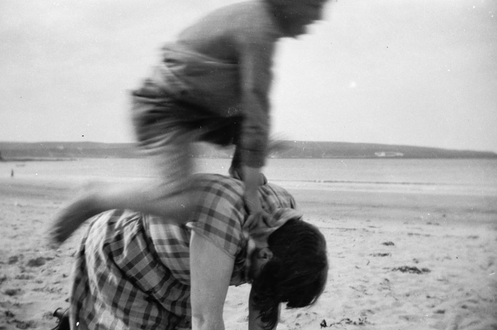 a black and white photo of two people on a beach