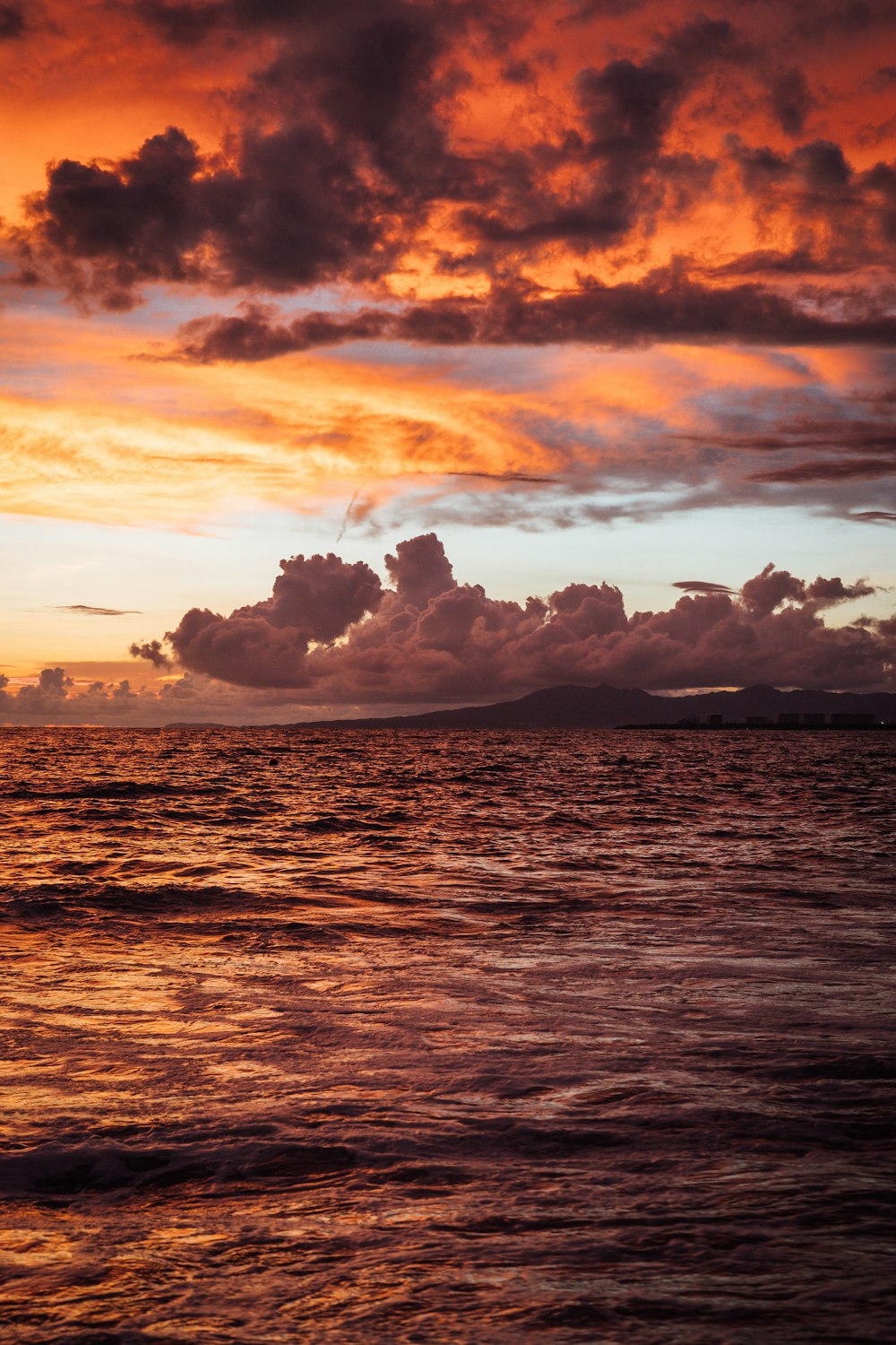 a sunset over a body of water with clouds in the sky