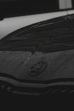 Close-up of water droplets sparkling on a freshly cleaned car hood.