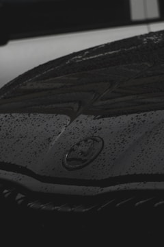 A close-up of water droplets glistening on a freshly washed car hood.