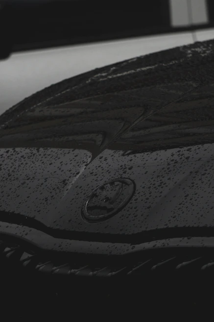Close-up of water droplets sparkling on a freshly cleaned car hood