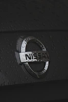 Close-up of a Nissan car emblem on a shiny hood
