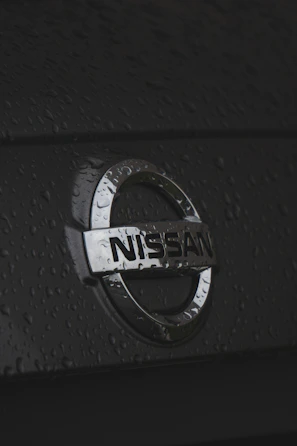 Close-up of a Nissan car emblem on a shiny hood