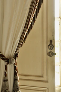 Elegant farmhouse door curtain gently swaying in a sunlit farmhouse entryway.