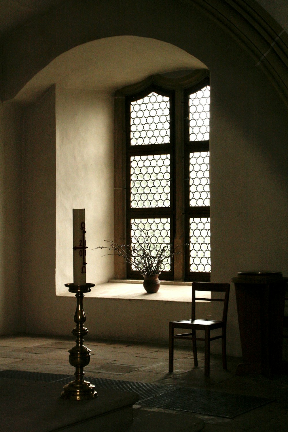 a table with a candle and a vase on it