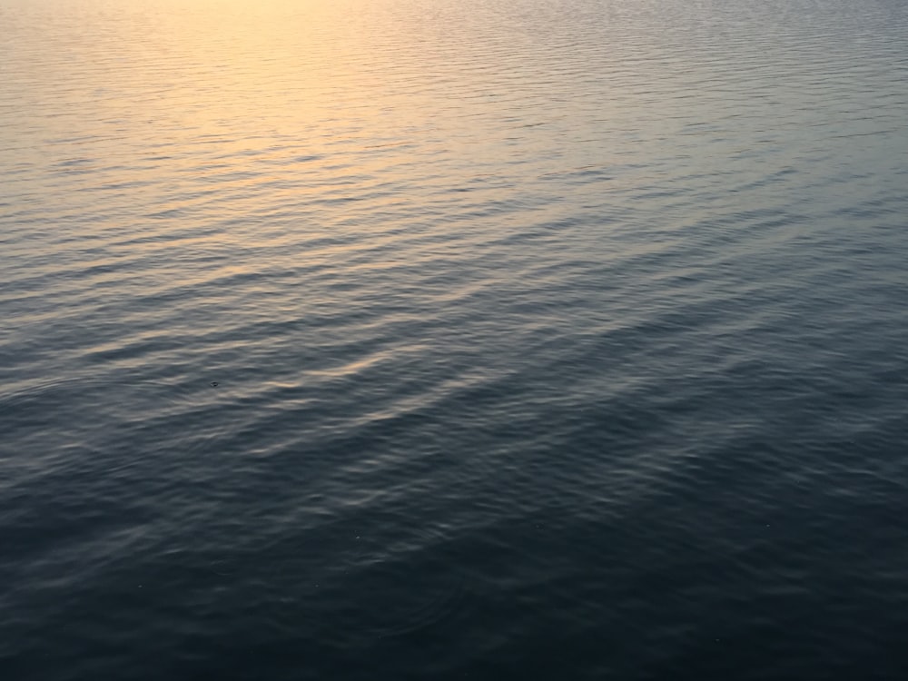 a large body of water with a boat in the distance