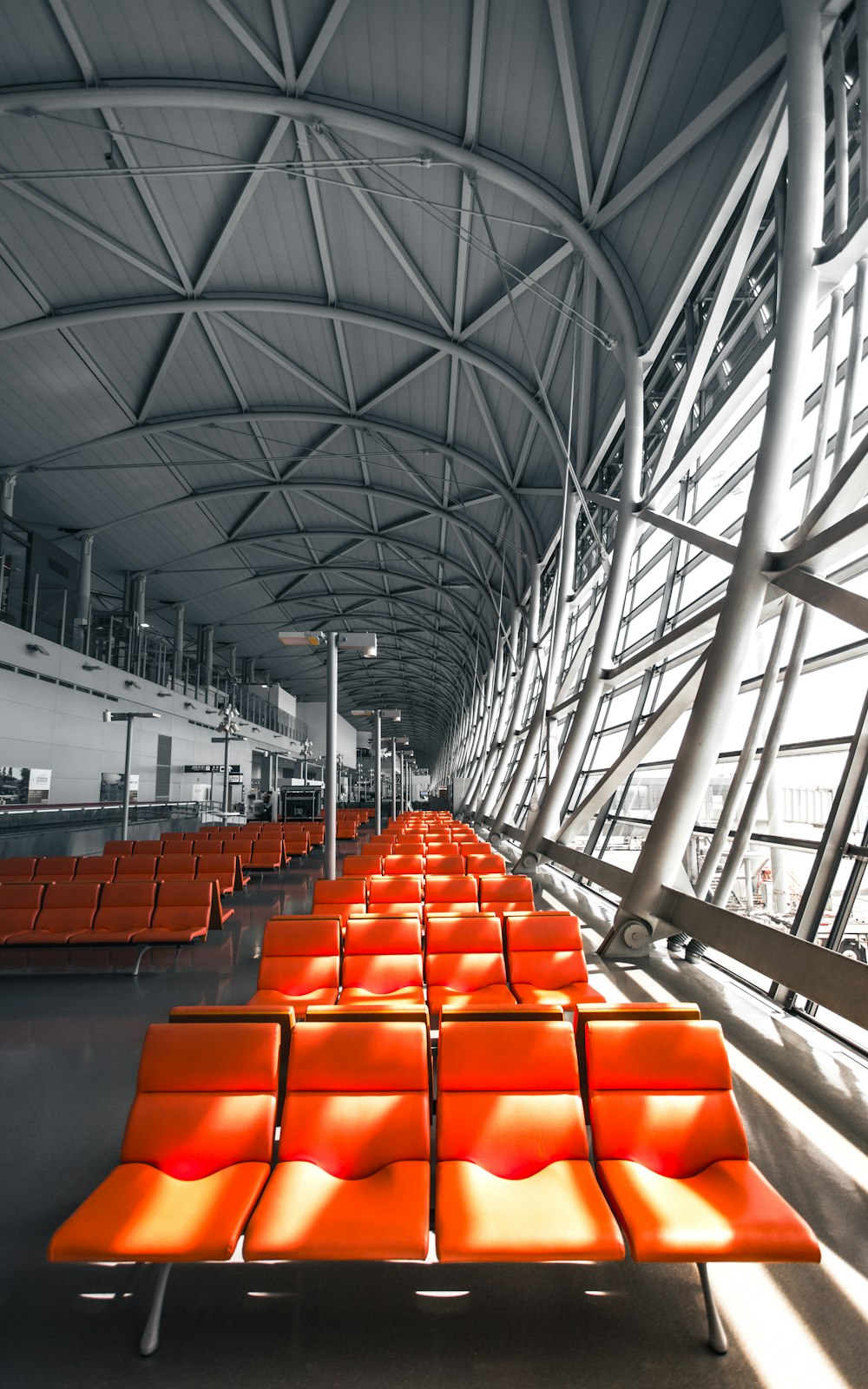 an airport terminal with rows of orange seats