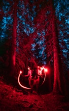 A glowing sensor node in a dark forest, highlighting early fire detection technology.