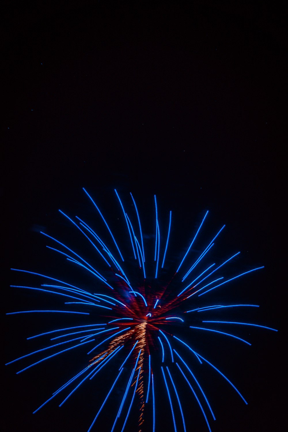 a blue and red firework in the night sky