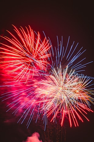 Vibrant fireworks bursting over the Bangor skyline at night, lighting up the sky in red, white, and blue.
