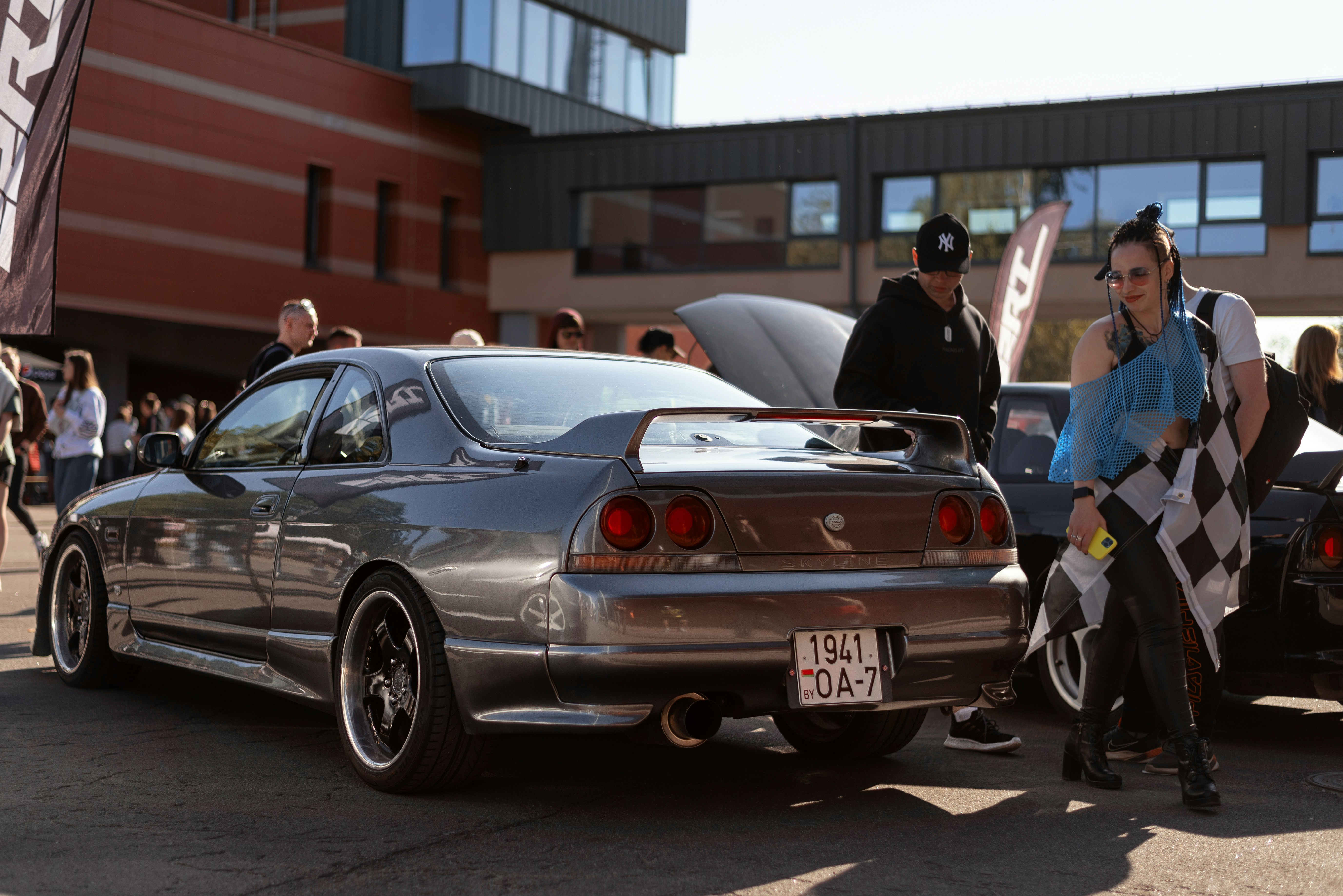 a woman standing next to a car with a checkered flag