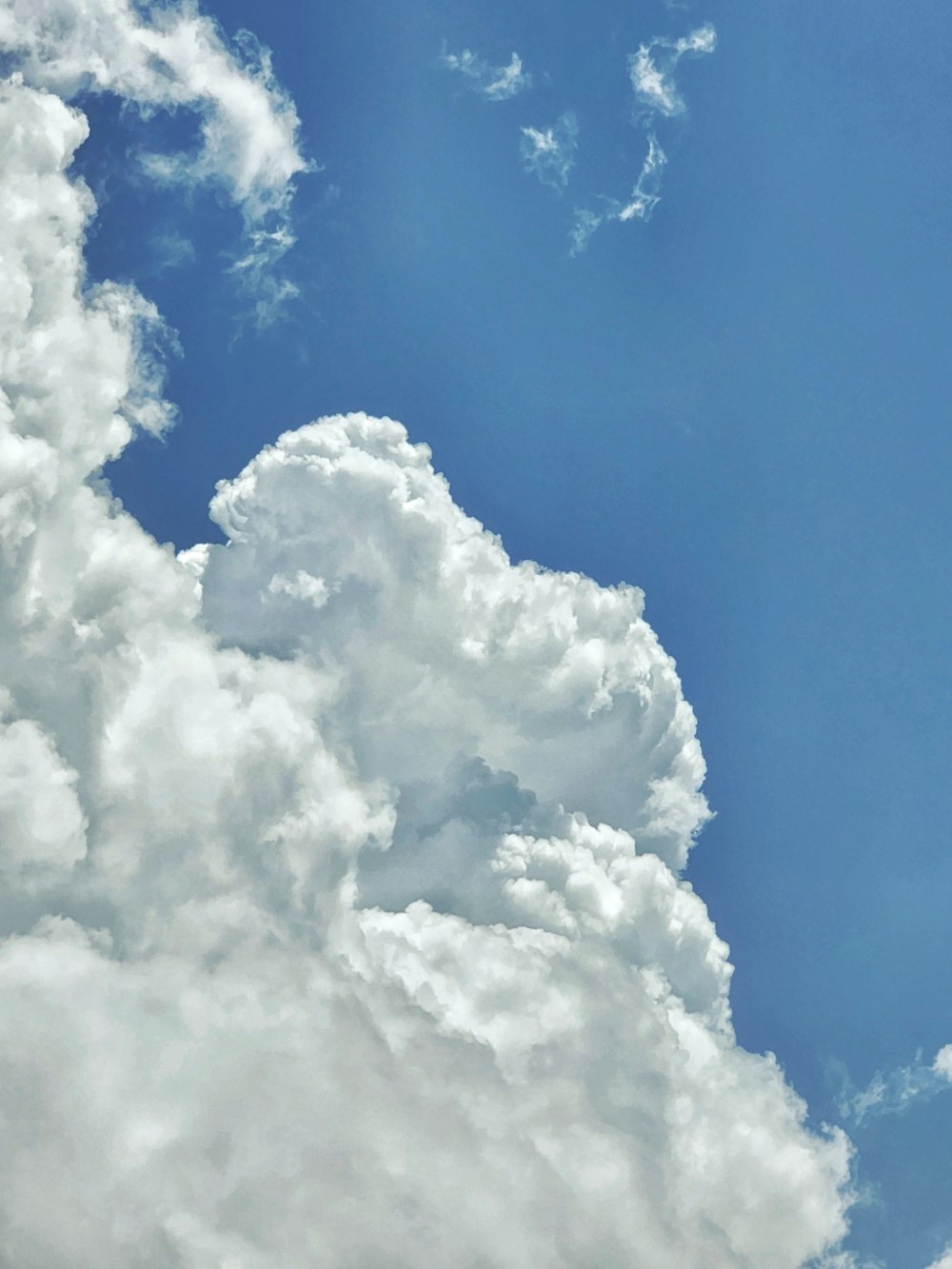 a plane flying through a blue cloudy sky