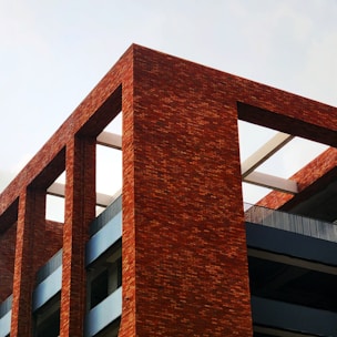 a red brick building with a clock on it's side