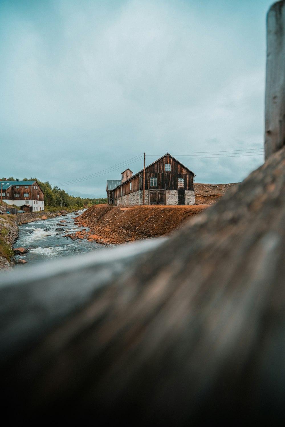 an old building sitting on top of a hill next to a river