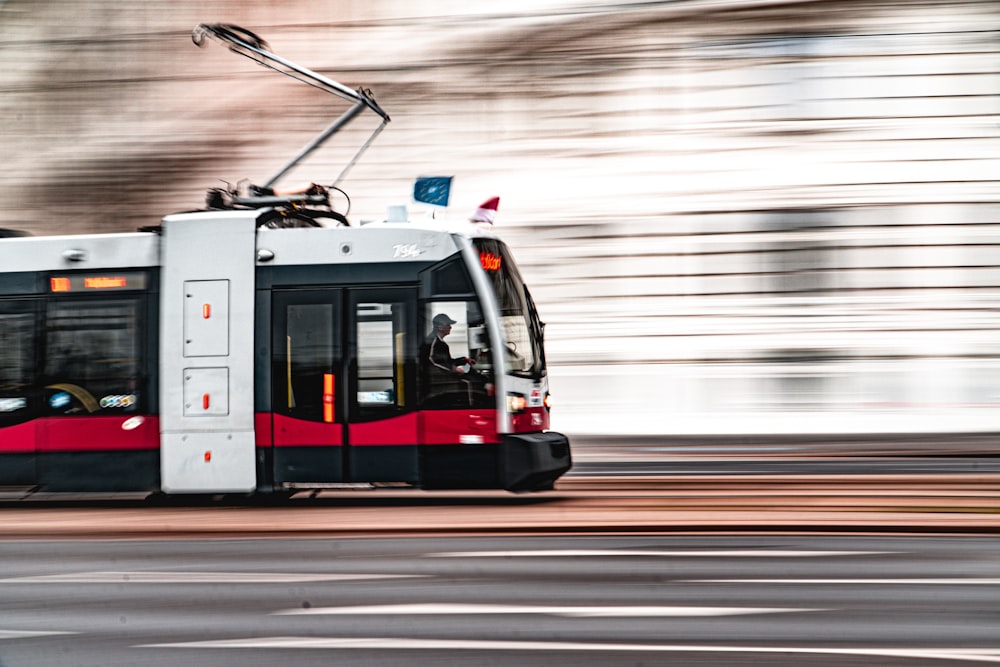 a red and white bus driving down a street