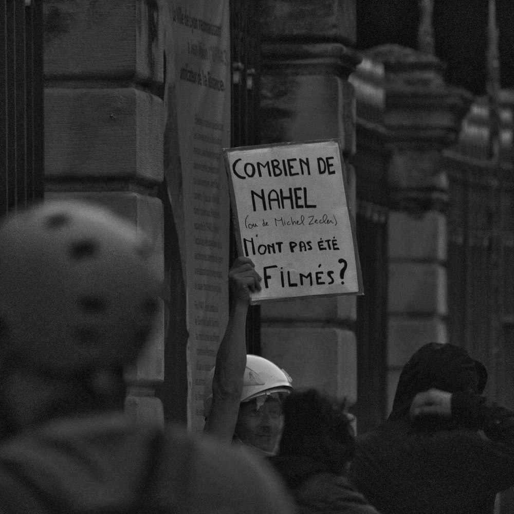 a person holding a sign that says comment de nahel
