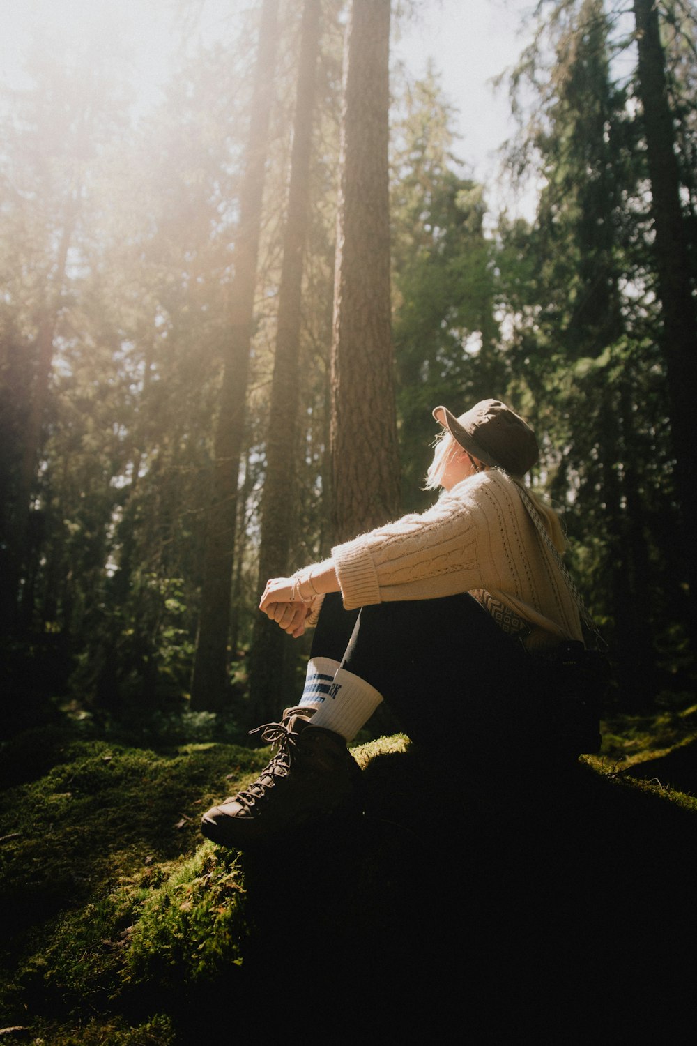 a person sitting on a rock in the woods