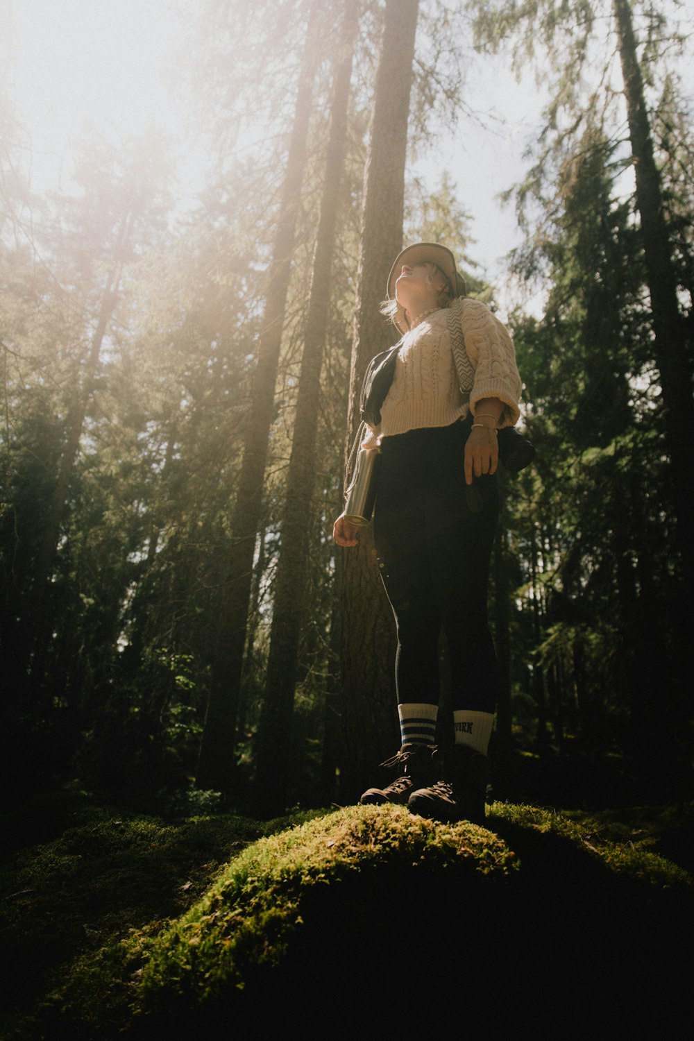 a woman standing in the middle of a forest