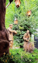 a couple of statues sitting next to a tree